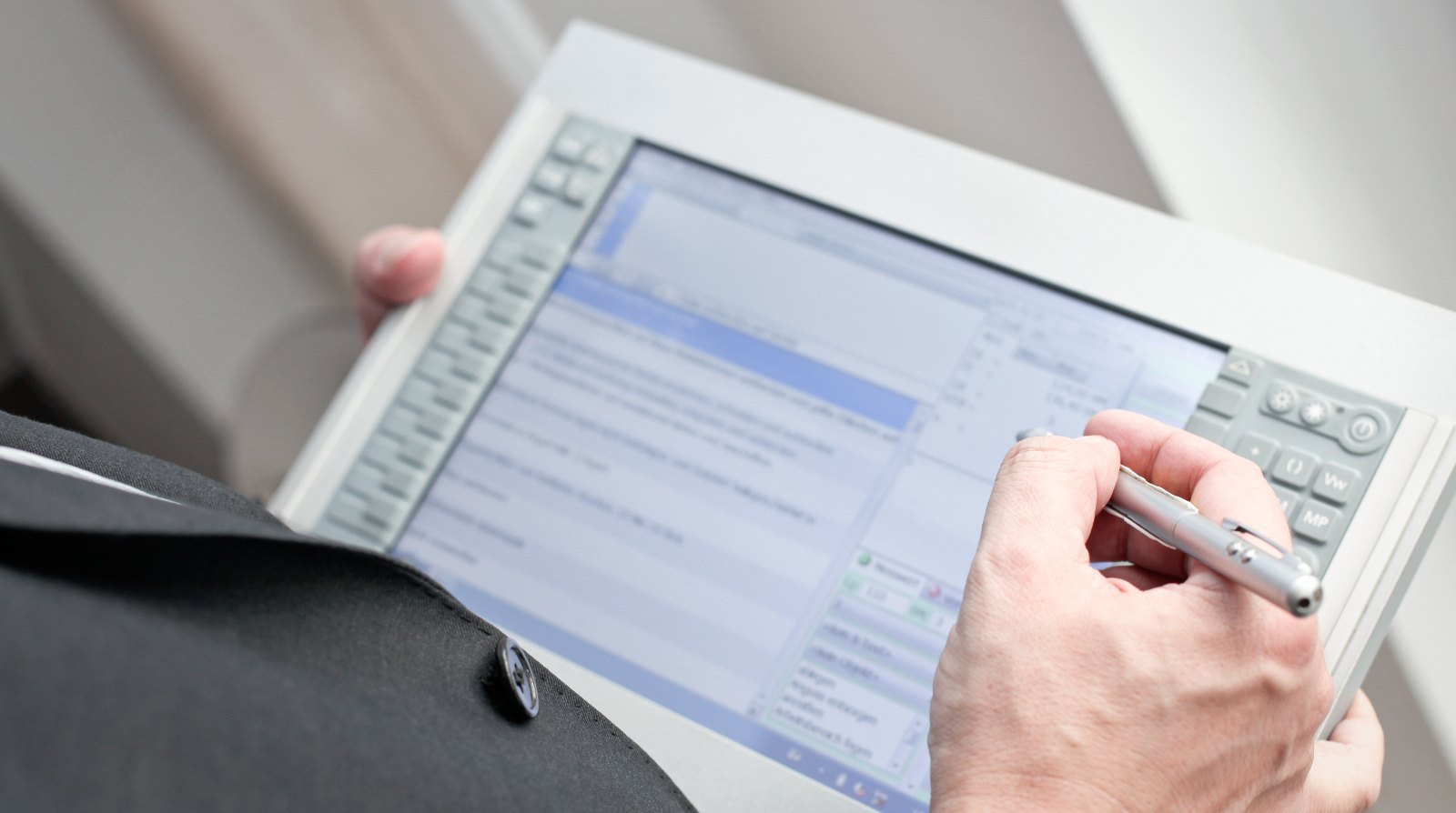 Zeitaufnahme am Arbeitsplatz: Erfassungsgerät mit laufender Zeitstudie in der Hand